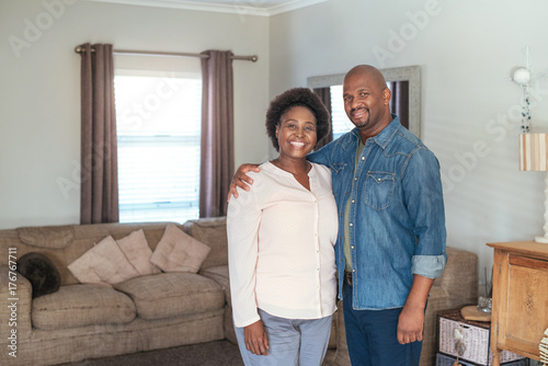 Affectionate African couple standing together in their living room