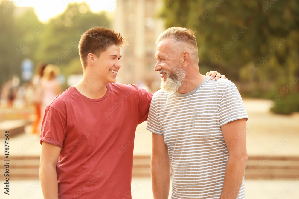 Teenager boy with grandfather in park