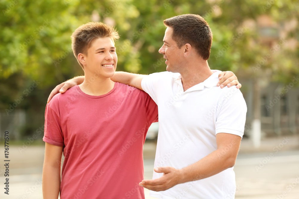 Teenager boy with father in park