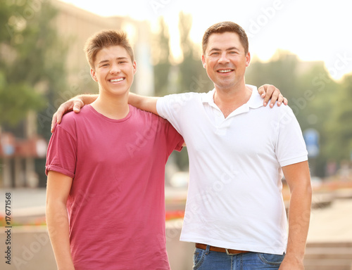 Teenager boy with father in park © Africa Studio