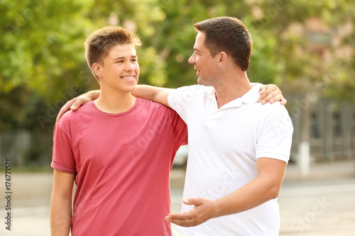 Teenager boy with father in park