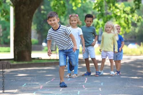 фотографія Little children playing hopscotch, outdoors