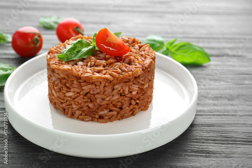 Plate with delicious brown rice on table