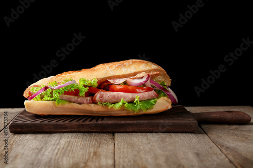 Delicious sausage sandwich on wooden board