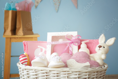 Wicker basket with baby shower gifts indoors