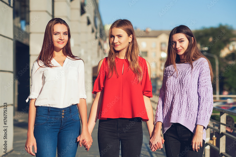 Group of casual young girls. Woman's friendship. Youth fashion. Crop of diverse informal students standing in row outdoors urban background Group of casual young girls. Woman's friendship. Youth fashion. Crop of diverse informal students standing in row outdoors urban background