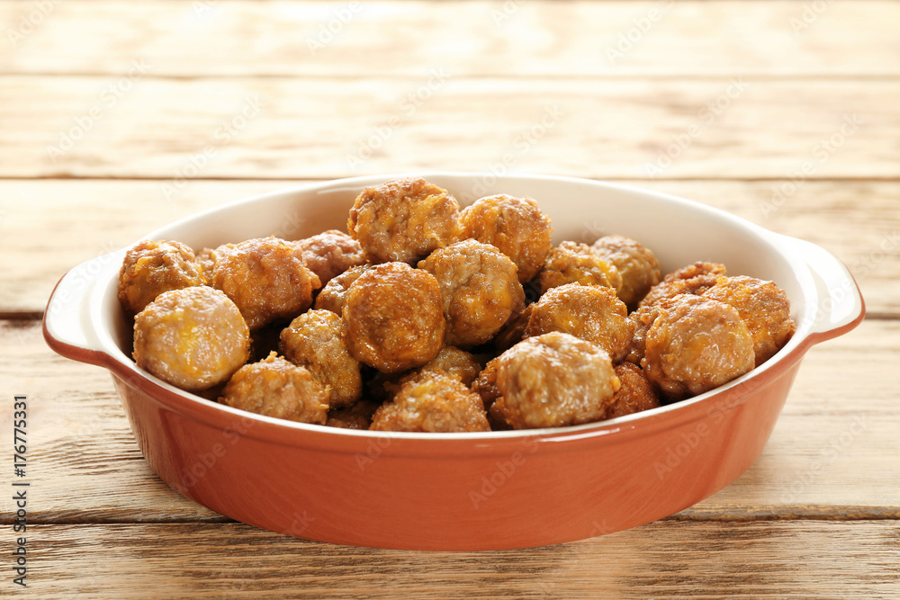 Casserole dish with sausage cheese balls on wooden background Casserole dish with sausage cheese balls on wooden background
