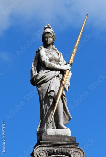 An old sculpture of white marble in the city park. City park sculpture