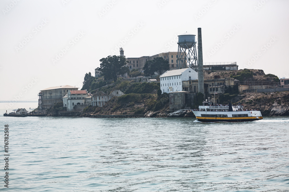 Tourist ferry boat and close up shots of Alcatraz Island in the San Francisco bay shot on a hazy summer day