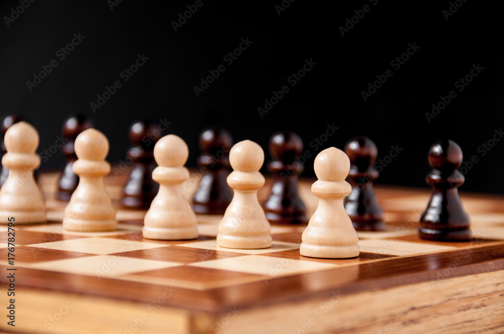 Still life on the chessboard: white and black pawns stand in a row Still life on the chessboard: white and black pawns stand in a row
