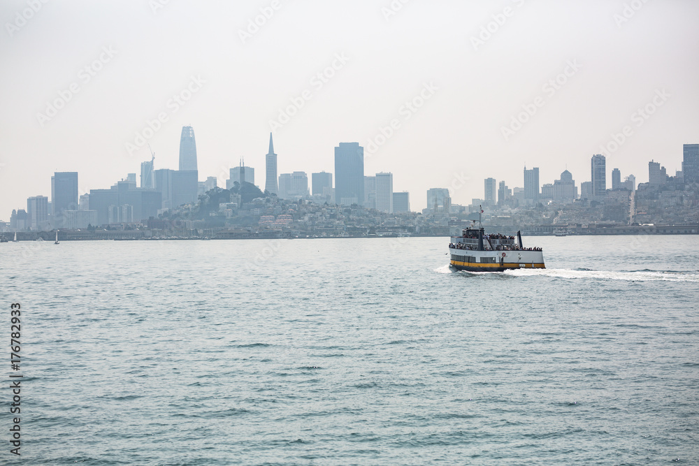 Tourist ferry boat near Alcatraz Island in the San Francisco bay shot on a hazy summer day Tourist ferry boat near Alcatraz Island in the San Francisco bay shot on a hazy summer day