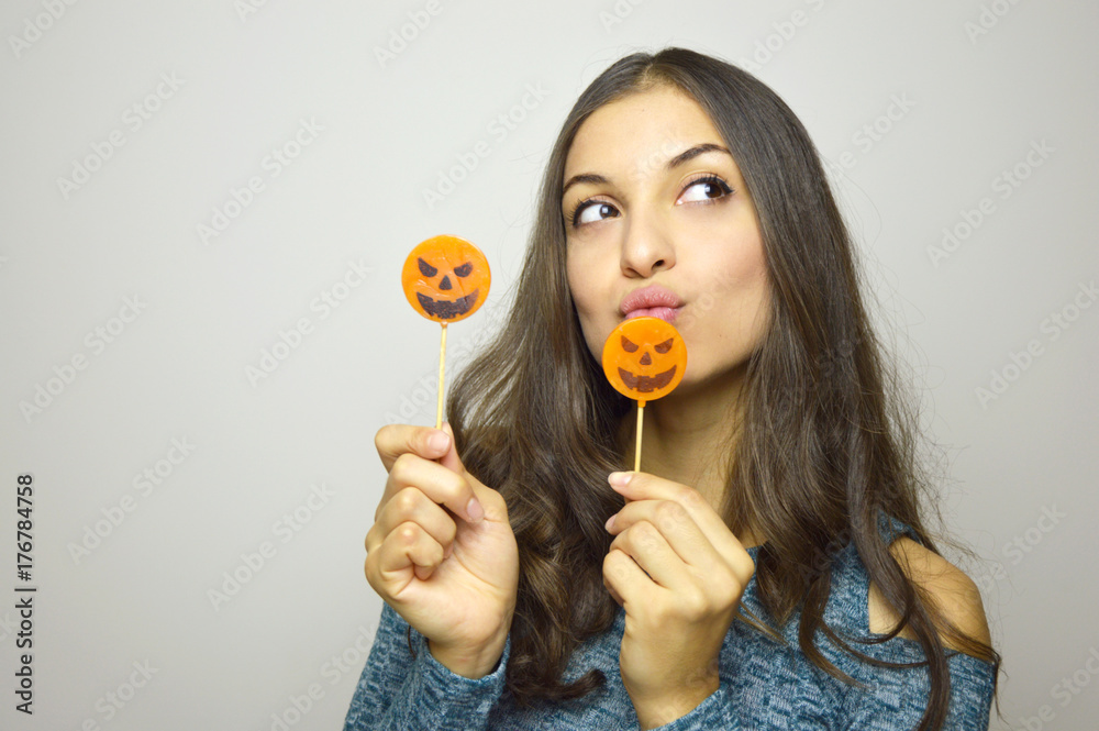 Young beautiful woman with halloween lollipops. Studio picture isolated on gray background. Young beautiful woman with halloween lollipops. Studio picture isolated on gray background.
