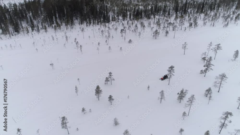 AERIAL: People driving snowmobiles on beautiful snowy mountain slope exploring Lapland, Finland. Tourists on snowmobile adventure joyride. Travelers snowmobiling during cold white winter in Norway AERIAL: People driving snowmobiles on beautiful snowy mountain slope exploring Lapland, Finland. Tourists on snowmobile adventure joyride. Travelers snowmobiling during cold white winter in Norway