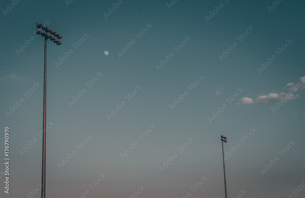 Halogen spotlights over field. Stadium lights. Blue sky background. Blue cloudy sky background. Street lamps. Baseball field . Soccer field. Minimal art design.Abstract art. Minimalism.