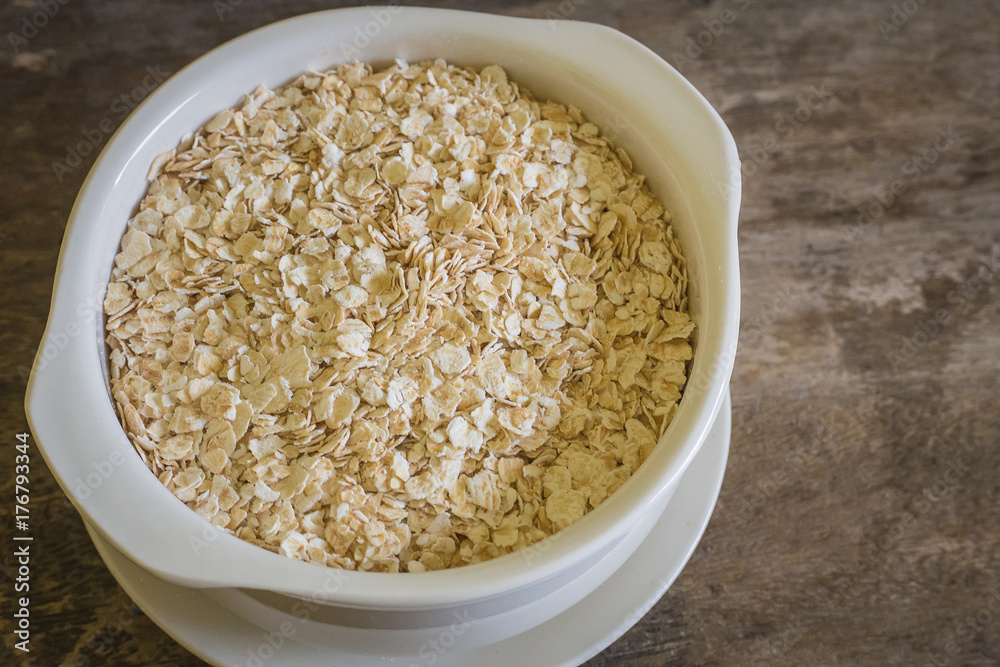 The oats rice in white bowl on top table wood worm tone image