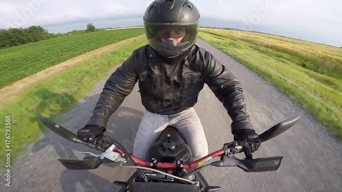 motorcycle rider cruising down gravel road shifting up gopro swivel cam photo