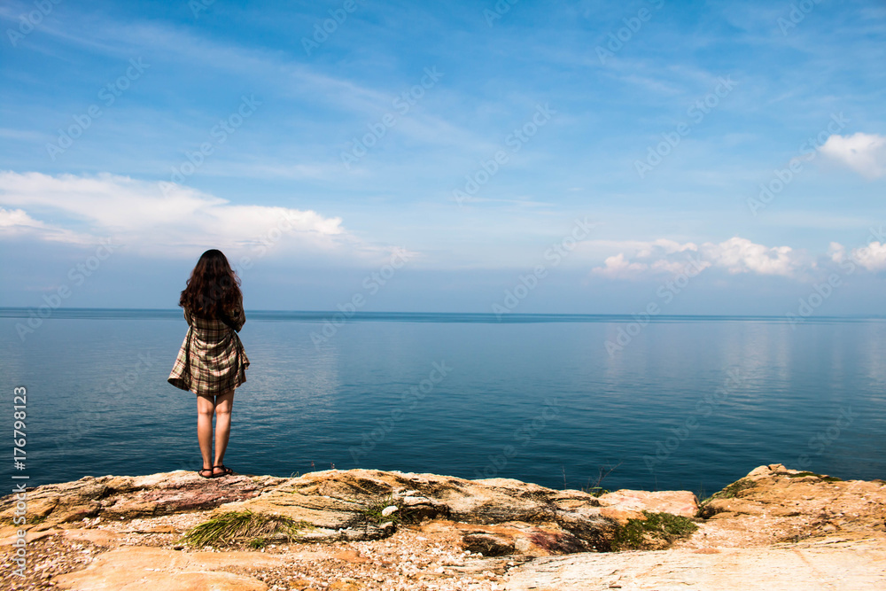 Backpacker girl stands on the viewpoint of the vast ocean. Backpacker girl stands on the viewpoint of the vast ocean.