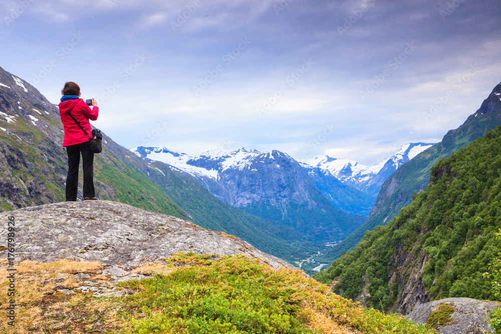 Tourist with camera taking picture in mountains Norway