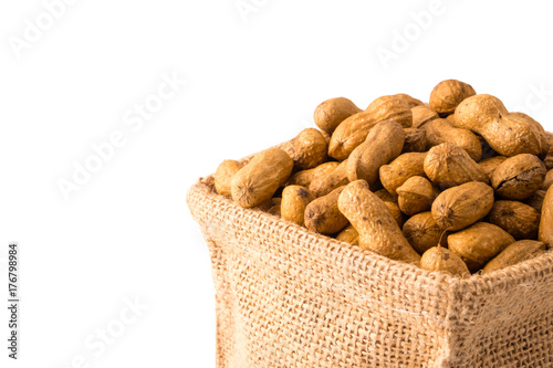 Peanuts in burlap bag on white background.