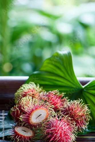 Rambutan in natural conditions on a beautiful tropical background. Exotic fruits