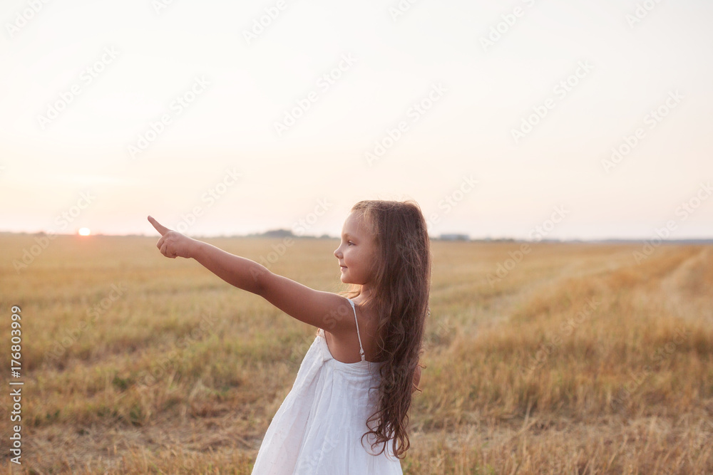 Little beautiful smiling girl on a gold wheat field walking at sunset. Happy five years old girl smiling and laughing in summer day at nature. Happyness freedom and carefree childhood concept Little beautiful smiling girl on a gold wheat field walking at sunset. Happy five years old girl smiling and laughing in summer day at nature. Happyness freedom and carefree childhood concept