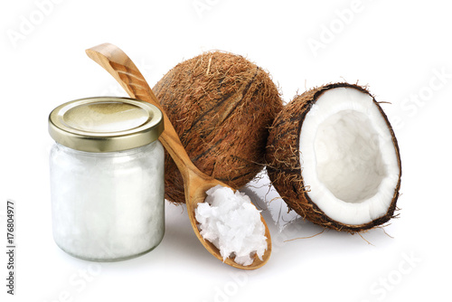 Coconut, glass jar and wooden spoon with coconut oil isolated on white background.