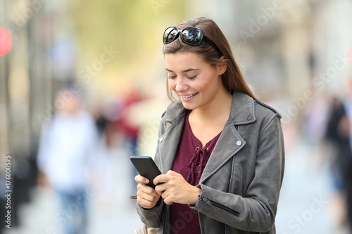 Fashion girl standing using a smart phone on the street