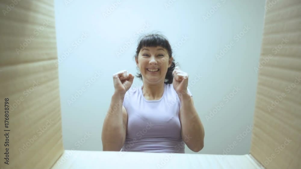 Young woman looks in the box, is surprised and happy to receive a surprise. Girl opened a box with a gift. Slow Motion. Young woman looks in the box, is surprised and happy to receive a surprise. Girl opened a box with a gift. Slow Motion.