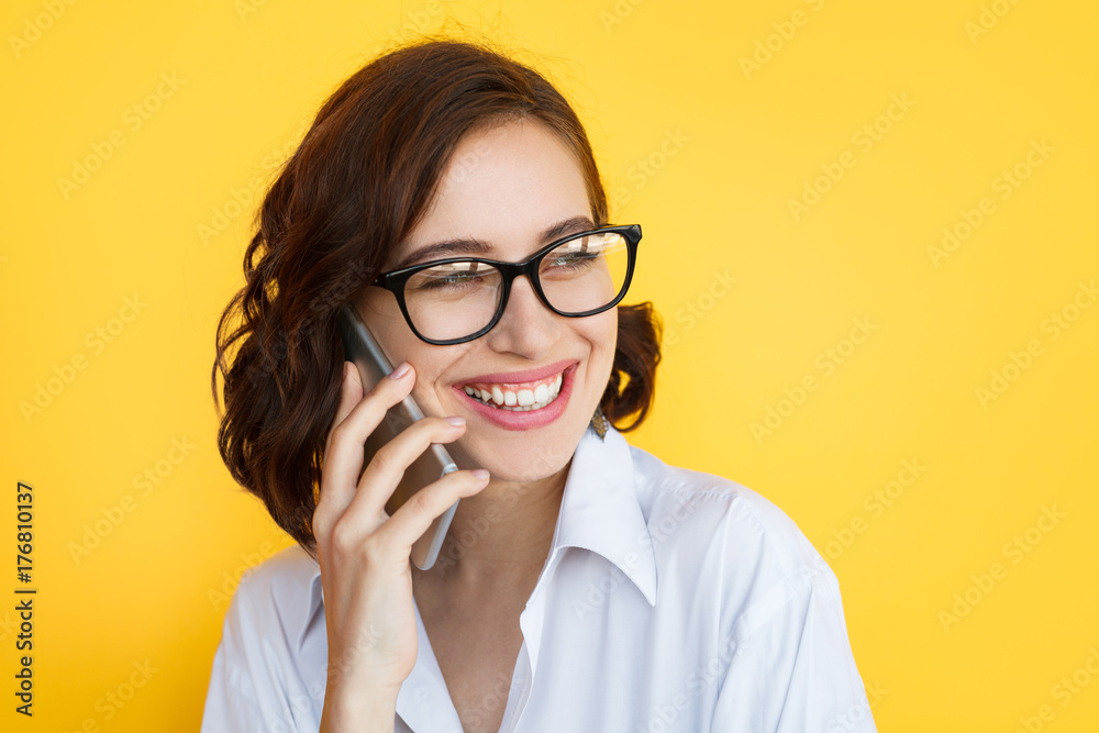 Laughing girl in eyeglasses talking phone