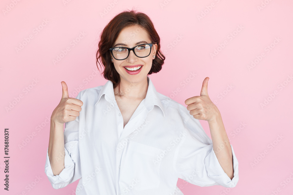 Smiling woman in glasses holding thumbs up Smiling woman in glasses holding thumbs up