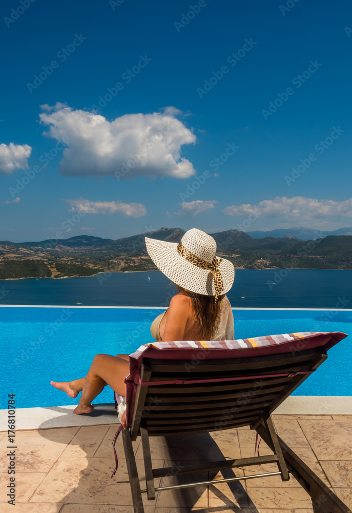 Woman enjoying relaxation in pool and looking at the view