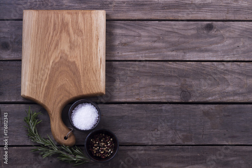 Cutting Board, rosemary and spices on a old wooden table. Copy space. Concept for restaraunt cafe bistro menu photo