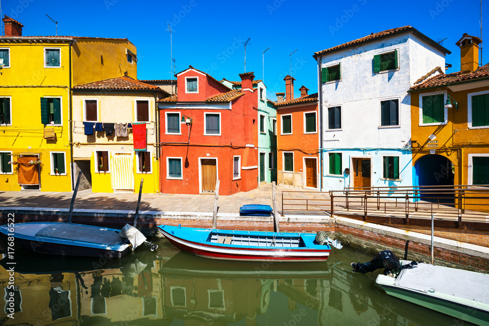 Venice landmark, Burano island canal, colorful houses and boats, Italy