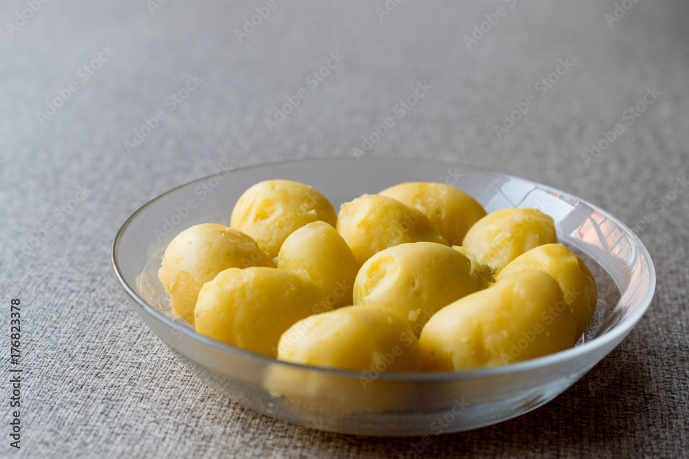 Boiled Potatoes in glass bowl on grey surface. Boiled Potatoes in glass bowl on grey surface.