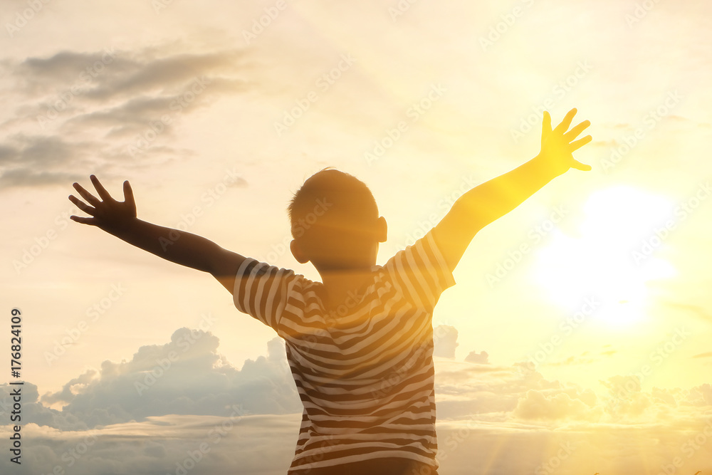 Fototapeta premium The boys spread arms, sun and sky.