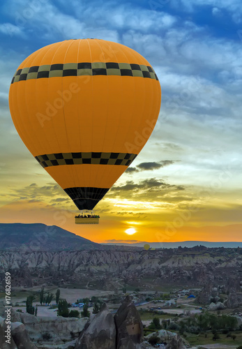 Hot air balloon flying over rock landscape