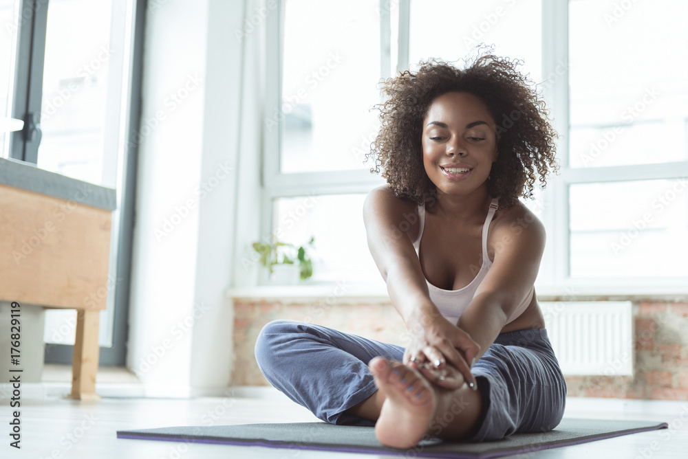 Smiling female doing pilates at home Smiling female doing pilates at home