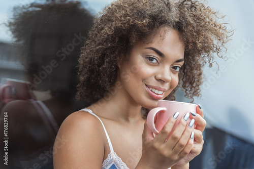 Cheerful female tasting appetizing tea