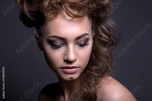 Portrait of a beautiful girl with a creative high hairstyle and makeup.