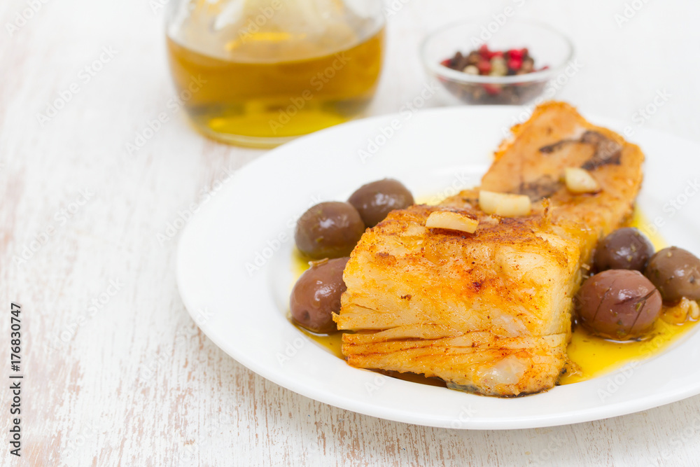 fried cod fish with garlic and olive oil on dish