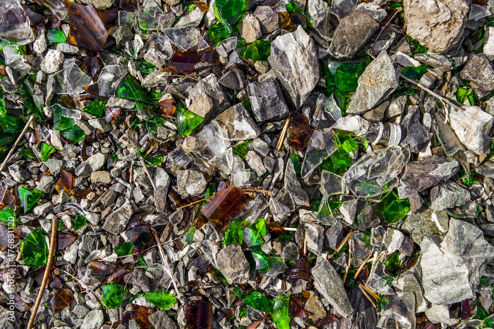 Shards of glass on shards of stone. Glass debris. Broken bottles. Background and texture
