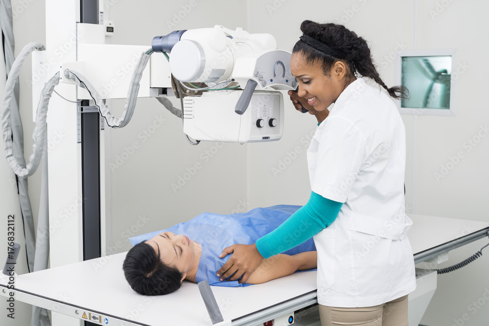 Radiologist Taking X-ray Of Mature Patient Lying On Gurney Radiologist Taking X-ray Of Mature Patient Lying On Gurney