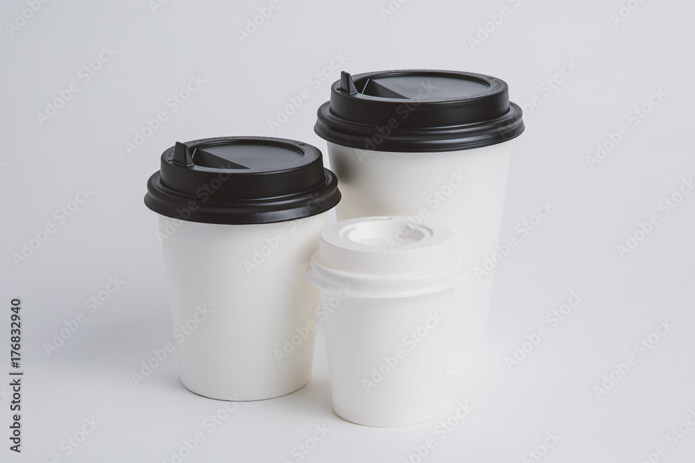 Mockup image of three paper cups with cap on clean bacground Mockup image of three paper cups with cap on clean bacground