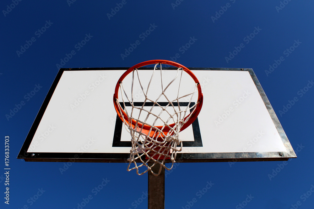 Basketball hoop against blue sky in a playground seen from under the rim (hoop) Basketball hoop against blue sky in a playground seen from under the rim (hoop)