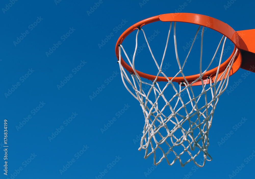Orange basketball rim (hoop) and white net against blue sky