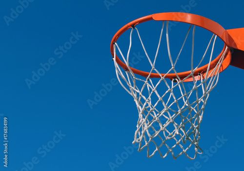 Orange basketball rim (hoop) and white net against blue sky © maciejmatteo
