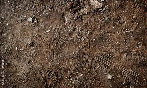 Wet ground with footprints. Mud ground with human footprints. Soil background photo