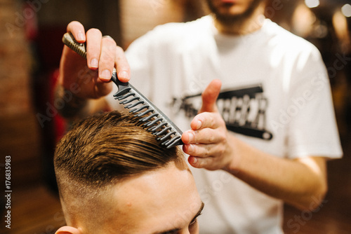 Haircut men Barbershop. Men's Hairdressers. barbers. The hairdresser combs his hair to the client. The stylist makes the male hipster classic hair styling
