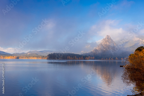 Beautiful wide panorama of autumnal landscape with mountain lake. © stone36