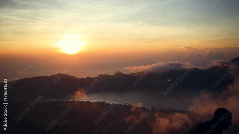 Silhouette of woman taking picture with smart phone camera enjoying sunrise, View from Mount Batur on Volcano Agung and Abang, Bali, Indonesia. Silhouette of woman taking picture with smart phone camera enjoying sunrise, View from Mount Batur on Volcano Agung and Abang, Bali, Indonesia.